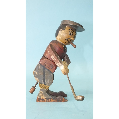 453 - A wooden toy in the form of a golfer teeing off, the figure twisting from the waist, constructed fro... 