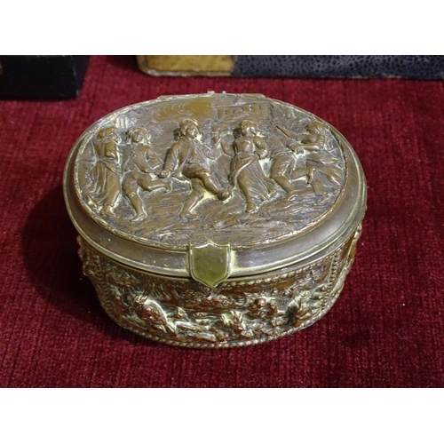 165 - A late-19th century French copper oval jewellery box, the lid decorated in relief with figures danci... 