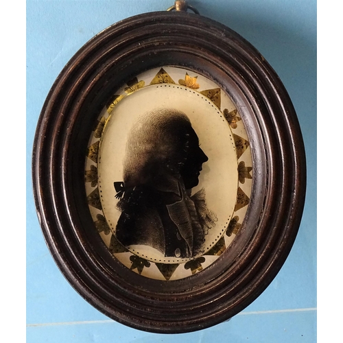 109 - A late-18th century silhouette painted on convex glass of an unknown gentleman, in black and shades ... 