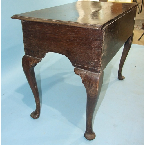 140 - An 18th century oak lowboy, the rectangular top with moulded edge above three small drawers, on cabr... 