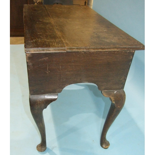 140 - An 18th century oak lowboy, the rectangular top with moulded edge above three small drawers, on cabr... 