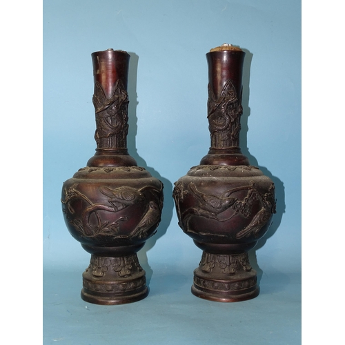 208 - A pair of 19th century Japanese bronze vases with birds and floral embossed decoration, 36cm high.... 