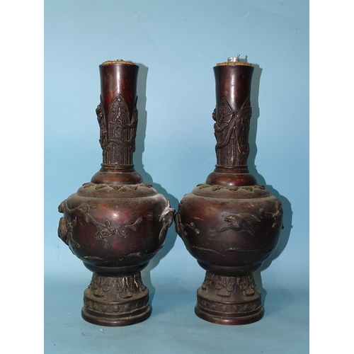 208 - A pair of 19th century Japanese bronze vases with birds and floral embossed decoration, 36cm high.... 