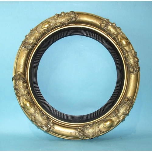 223 - An early-Victorian gilt gesso convex mirror frame with ebonised reeded slip, 56cm diameter.... 