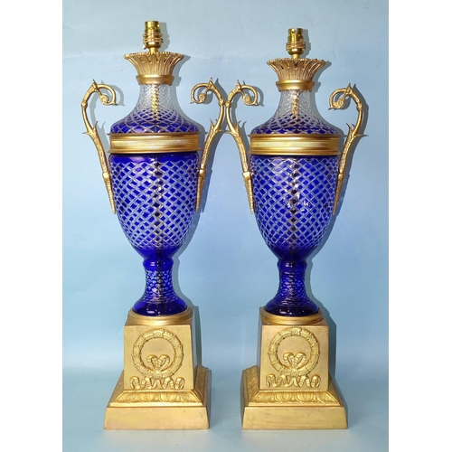 231 - A pair of contemporary gilt-metal-mounted blue overlay glass table lamps of two-handled urn shape, o... 