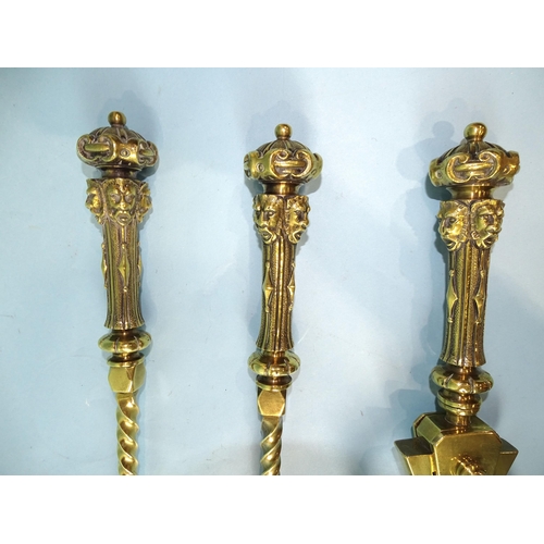 242 - A set of three heavy fire brasses, the handles with crown and masks decoration, twist columns, 72c, ... 