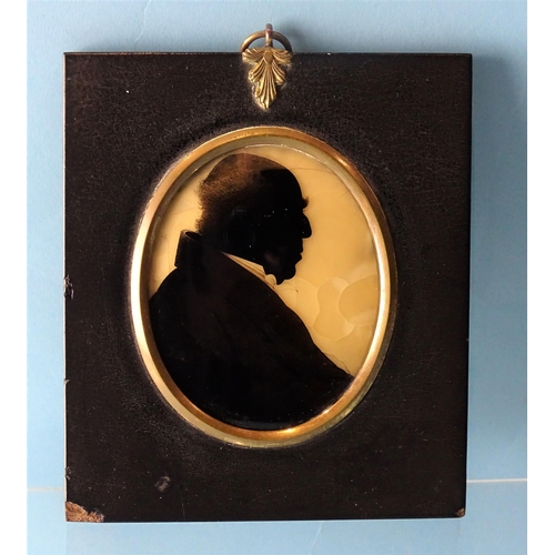 98 - An early-19th century silhouette of a gentleman, painted on convex glass backed with wax, labelled v... 