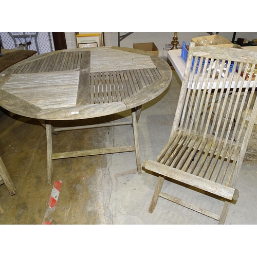 12 - A weathered teak circular slatted-top patio table, 125cm diameter and four matching folding chairs.... 