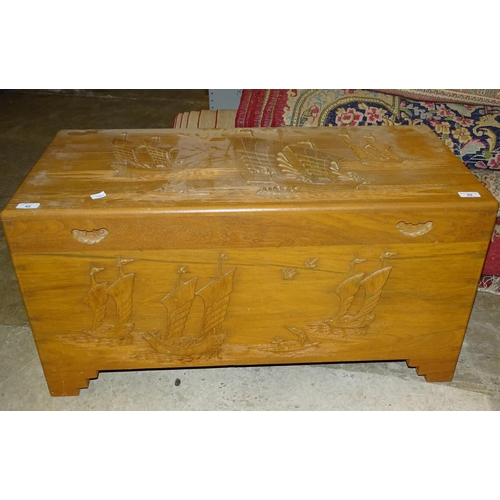 42 - A modern Oriental camphor wood blanket chest, the hinged lid and front carved with junks, 91 x 45cm,... 