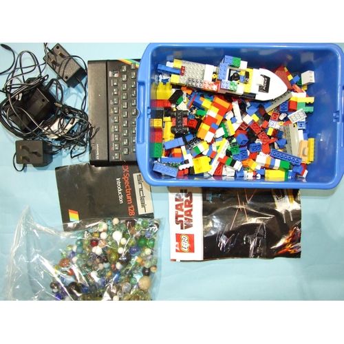 667 - A Sinclair ZX-Spectrum, with 128 leaflet (no games), a quantity of Lego, marbles and plastic figures... 