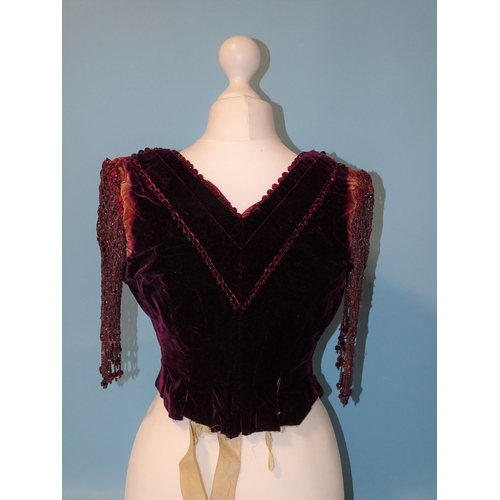 744 - An early-Victorian plum-coloured velvet bodice, the neckline trimmed with faceted red glass beads, t... 