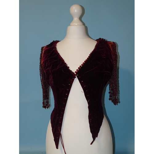 744 - An early-Victorian plum-coloured velvet bodice, the neckline trimmed with faceted red glass beads, t... 