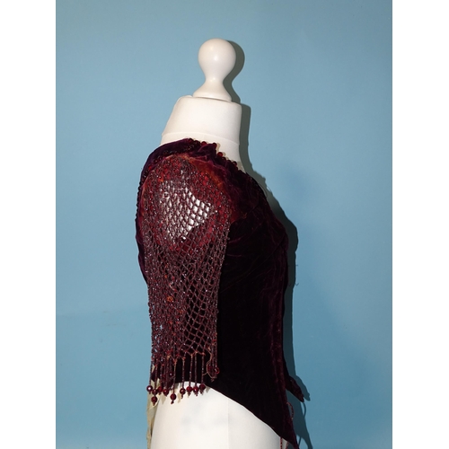 744 - An early-Victorian plum-coloured velvet bodice, the neckline trimmed with faceted red glass beads, t... 