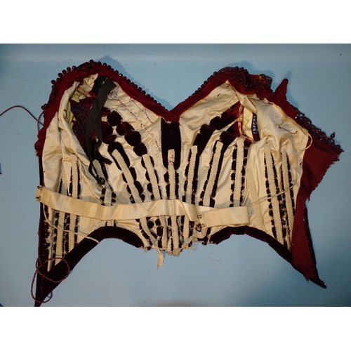 744 - An early-Victorian plum-coloured velvet bodice, the neckline trimmed with faceted red glass beads, t... 