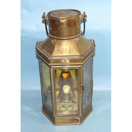 772 - An early-20th century brass oil lamp, with three glazed side panels enclosing an oil lamp burner, by... 