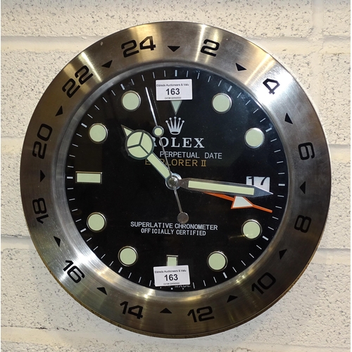 163 - A Rolex-style dealers circular battery-operated wall clock with silver-coloured rim, 34cm diameter.... 