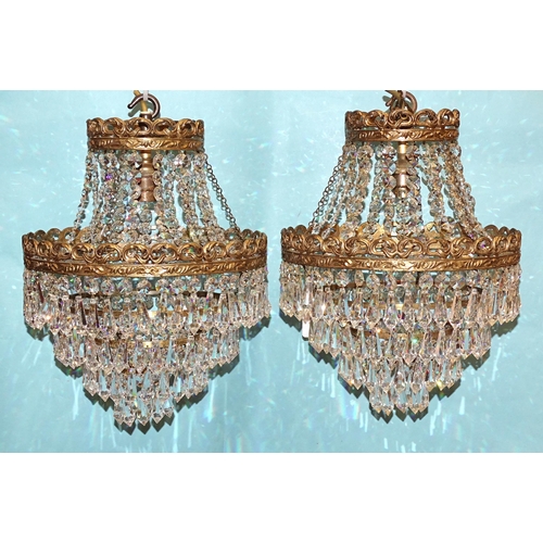 92 - A pair of four-stage gilt metal hanging light fittings with cut-glass drops, complete with ceiling r... 