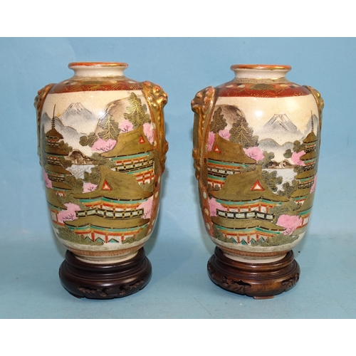 128 - A pair of small baluster Satsuma decorated Japanese vases, with lion mask handles and figures in a l... 