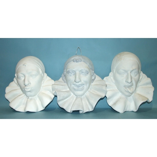 105 - A set of three moulded plaster wall plaques, each in the form of a clown's head wearing a different ... 