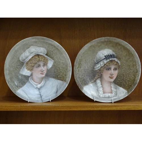 124 - A pair of Derby ceramic plates, each painted with a portrait of a young woman wearing a mob cap, 23.... 