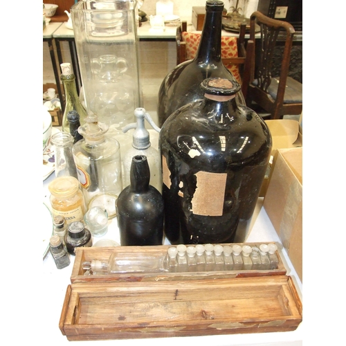 104 - A large amber glass shaped carboy, a liquid paraffin pharmaceutical bottle with pourer, other glass ... 