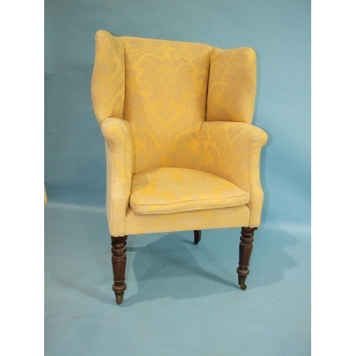 30 - A Georgian mahogany wing tub chair, the upholstered high back raised on turned mahogany front legs a... 