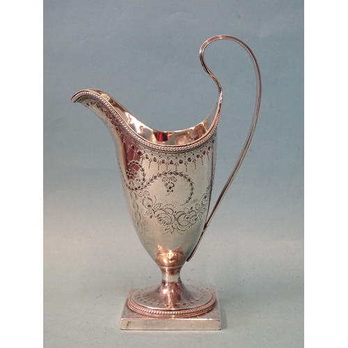 333 - A George III silver cream jug of helmet shape with reeded handle, on pedestal foot with square base,... 