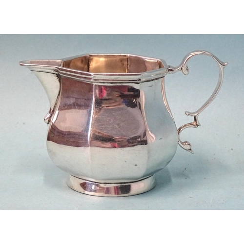 337 - A small silver cream jug of octagonal bellied form, with scroll handle, 6.5cm high, London 1905, ___... 