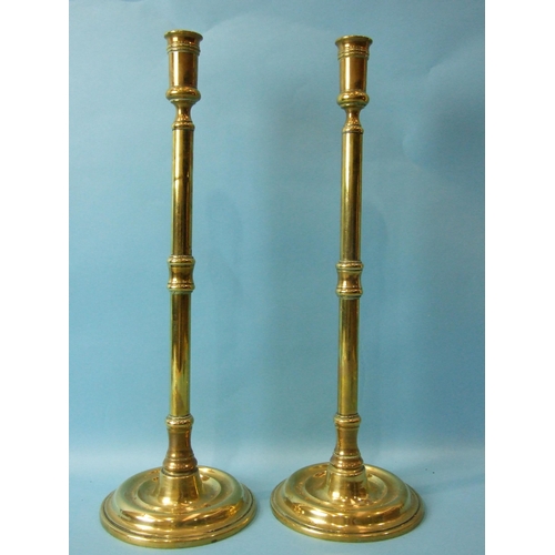 72 - A pair of brass 19th century tall candle holders on turned circular bases, 43cm high and three other... 