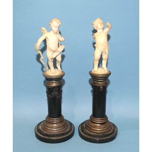 61 - A pair of early-20th century Continental white metal-mounted serpentine columns surmounted by carved... 