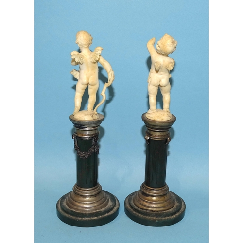 61 - A pair of early-20th century Continental white metal-mounted serpentine columns surmounted by carved... 