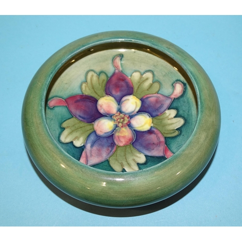 195 - A Moorcroft small circular dish with columbine tubelined decoration on a green ground, impressed 'Mo... 