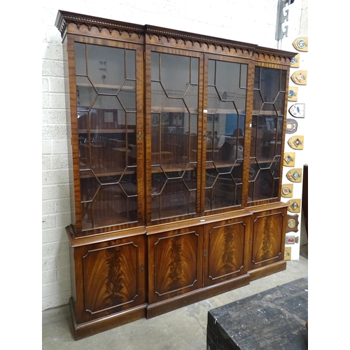 16 - A reproduction Georgian-style mahogany breakfront bookcase, the cornice above four astragal-glazed d... 