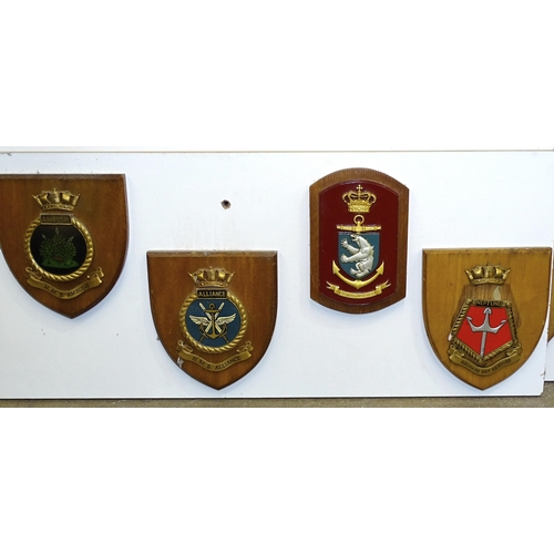 161 - A collection of twenty-eight various naval and other plaques attached to two painted wooden boards.... 