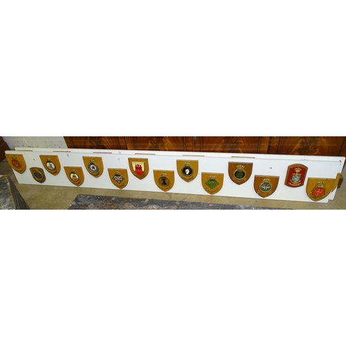 161 - A collection of twenty-eight various naval and other plaques attached to two painted wooden boards.... 