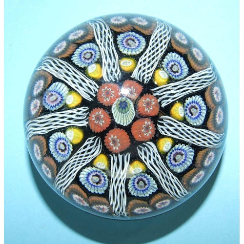 227 - A millefiori glass paperweight, the symmetrical group of vertical multi-coloured canes divided by ho... 