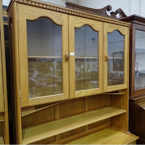 24 - A craftsman-made oak room divider, the upper section fitted with a pair of glazed doors enclosing a ... 