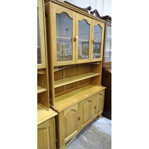 24 - A craftsman-made oak room divider, the upper section fitted with a pair of glazed doors enclosing a ... 