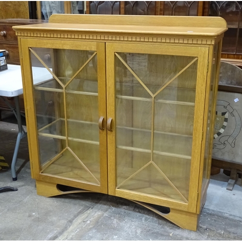26 - A craftsman-made oak display cabinet, the rectangular top above a pair of astragal-glazed doors, 119... 