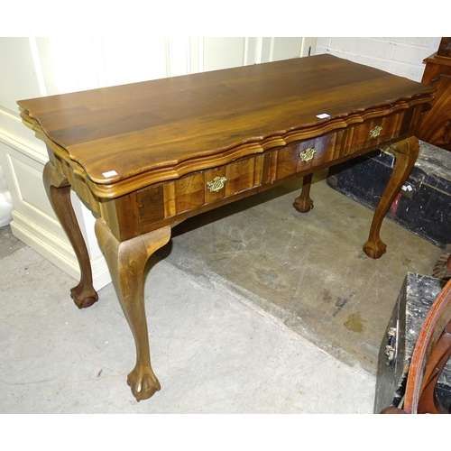 4 - A reproduction hardwood fold-over-top table fitted with three frieze drawers and shaped legs, on cla... 