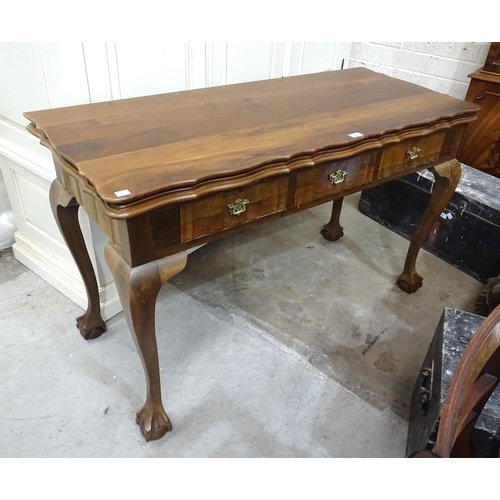 4 - A reproduction hardwood fold-over-top table fitted with three frieze drawers and shaped legs, on cla... 