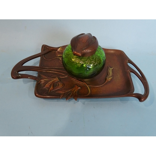 154 - An early-20th century German copper inkwell in the Art Nouveau style, with floral detail and green g... 