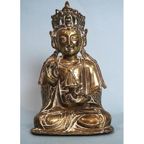 162 - A brass figure of a seated Buddha holding a cup in their left hand, 17cm high.