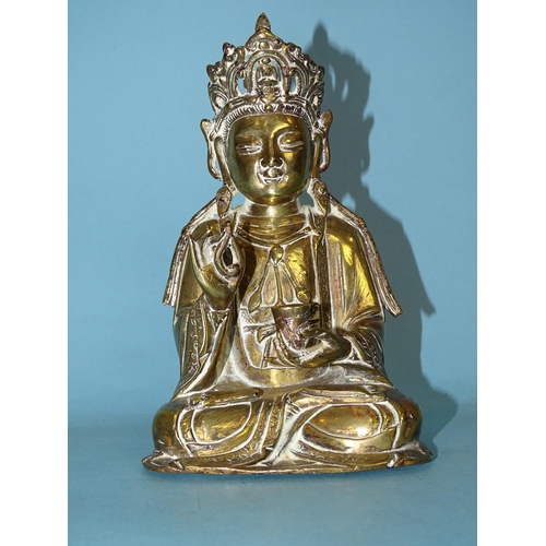 162 - A brass figure of a seated Buddha holding a cup in their left hand, 17cm high.