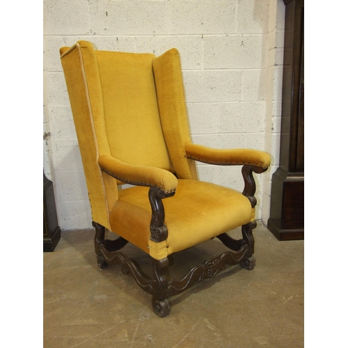 89 - A large generous-seated wing armchair on short cabriole legs joined by stretchers and an upholstered... 