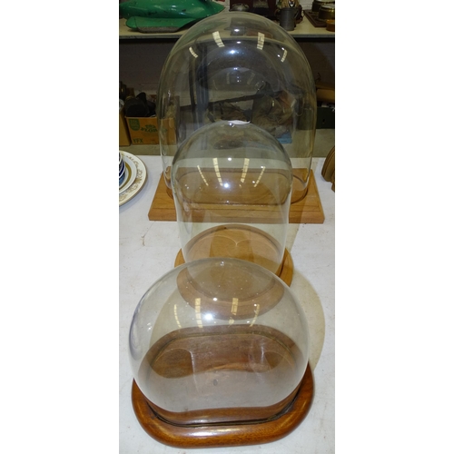 108 - A glass dome, internal measurements 31cm wide, 33cm high, 12.5cm deep, on modern wood stand, and two... 