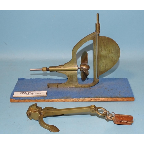 428 - A brass model of a Stern Frame clockwork rudder and propeller c1940, 21cm long, on stand and a brass... 