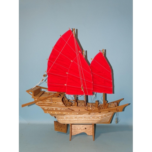 433 - A wooden model of a Chinese junk, on stand, 60cm long.