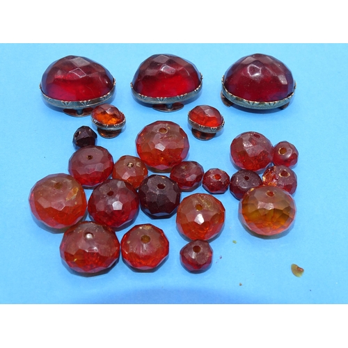 424 - Three large faceted amber lapel studs, two small ones, similar and a quantity of faceted amber beads... 