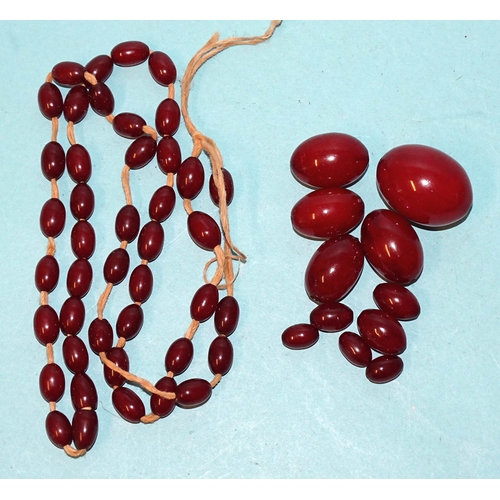 458 - A necklace of graduated cherry amber-type Bakelite beads, (needs restringing), largest bead 32 x 25m... 